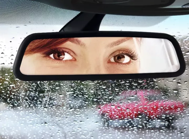 womans eyes seen in car rear view mirror